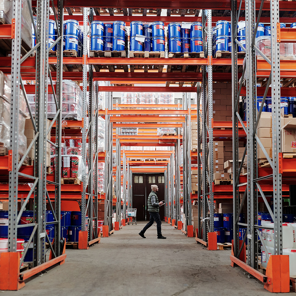 Stor lagerfacilitet med højt til loftet og et bredt udvalg af tønder, kasser, plastdunke m.m.